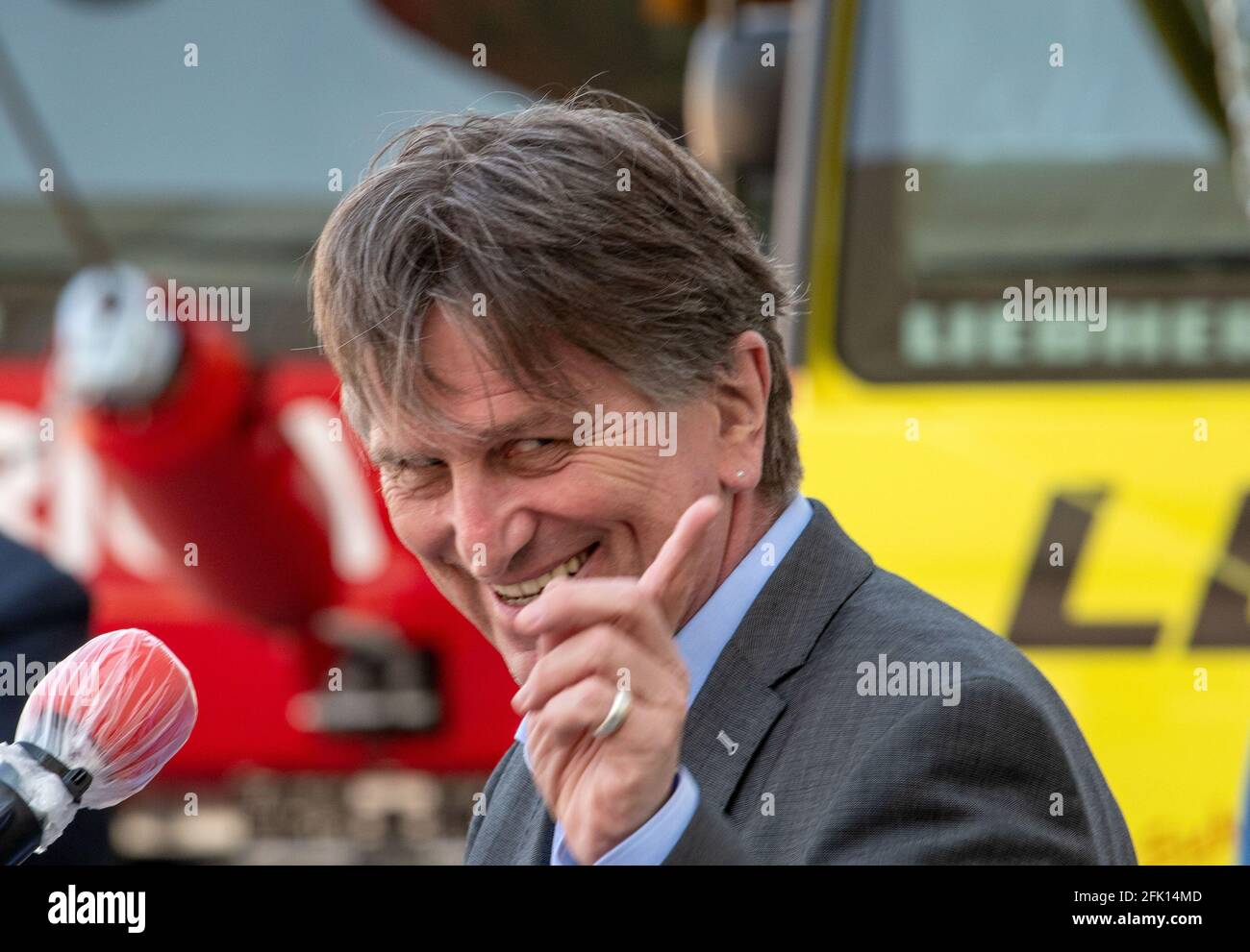 Ehingen, Germany. 27th Apr, 2021. Manfred (Manne) Lucha (Bündnis90/Die Grünen), Minister for Social Affairs and Integration of Baden-Württemberg, stands in front of a mobile crane of the engineering company Liebherr and speaks to journalists. The Liebherr factory in Ehingen has been chosen as a pilot plant for vaccinations by company doctors in Baden-Württemberg. The state's well-known vaccination prioritisation applies, so that employees aged 60 and over will be vaccinated as a first step. Credit: Stefan Puchner/dpa/Alamy Live News Stock Photo