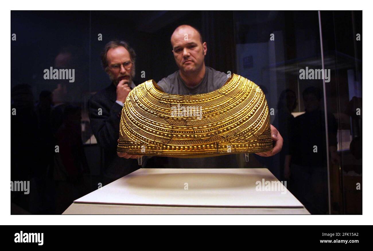 Being placed in its new case by museum Assistant Ian Taylor closely watched by Curator Stuart Needham, the newly restored Mold Gold Cape, dating to early Bronze Age (1900-1600BC) goes on display for the first time at the British Museum...The magnificent Mold cape was found around the bones of a skeleton in Flintshire, Wales in 1833.pic David Sandison 27/3/2002 Stock Photo