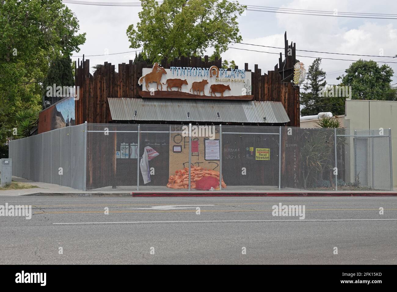 Burbank, CA / USA - April 25, 2021: Tinhorn Flats Saloon & Grill is shown  boarded up and surrounded by a chain-link fence installed by city officials  Stock Photo - Alamy