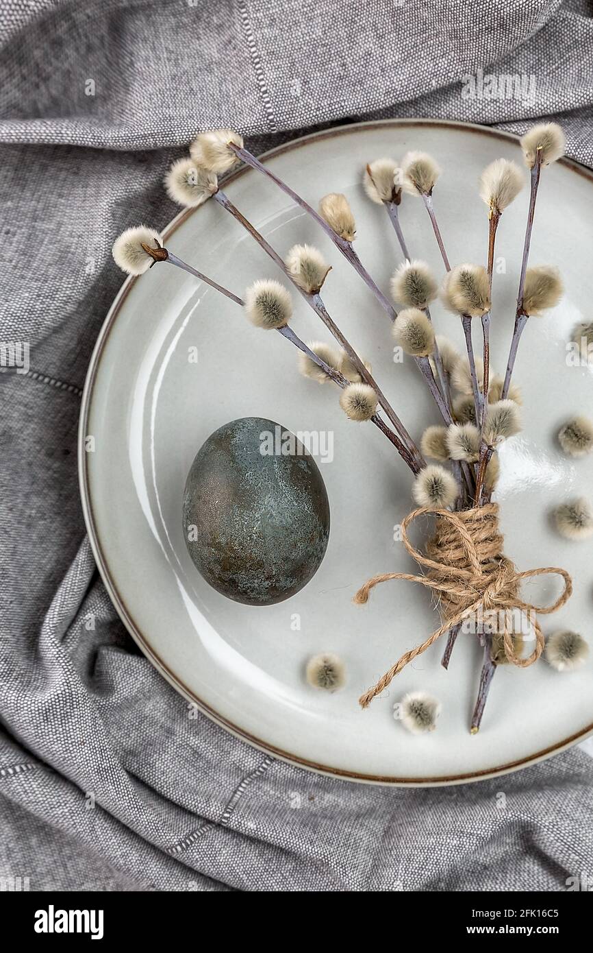 Easter picture with painted eggs on a plate. Willow branch. The minimal concept of Easter. An Easter card with a place for the text. Stock Photo