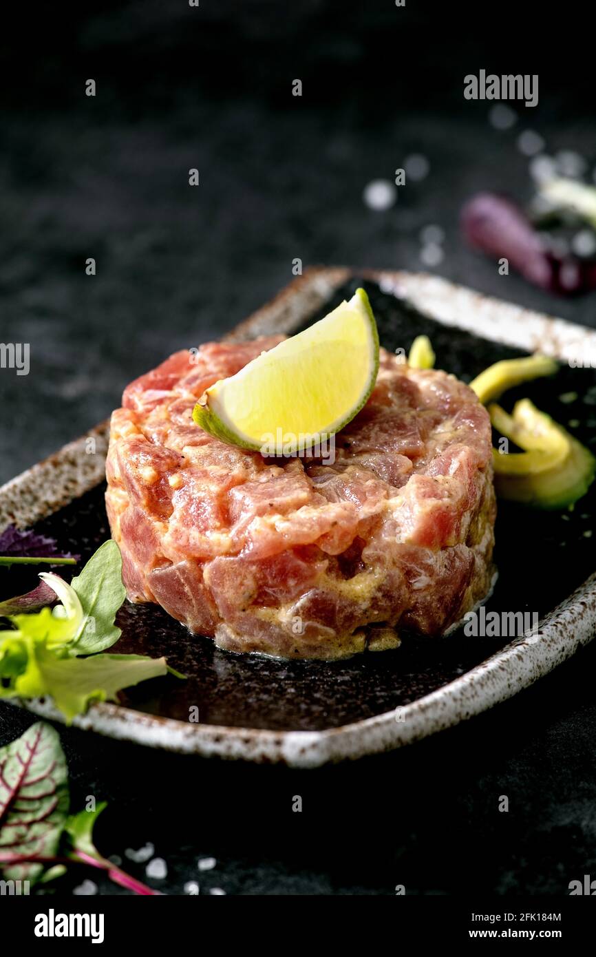 Tuna tartare with green salad, lime, avocado and mustard sauce serving