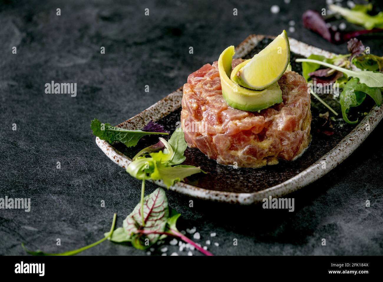 Tuna tartare with green salad, lime, avocado and mustard sauce serving
