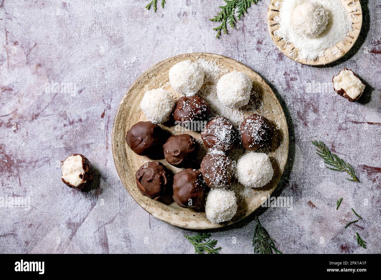Raw vegan homemade coconut chocolate candy balls with coconut flakes in