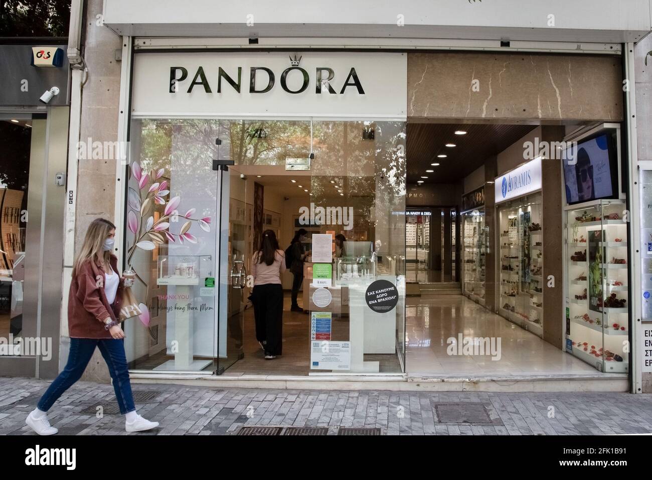 Athens, Greece. 27th Apr, 2021. A woman walks past a Pandora store at Ermou  steet close