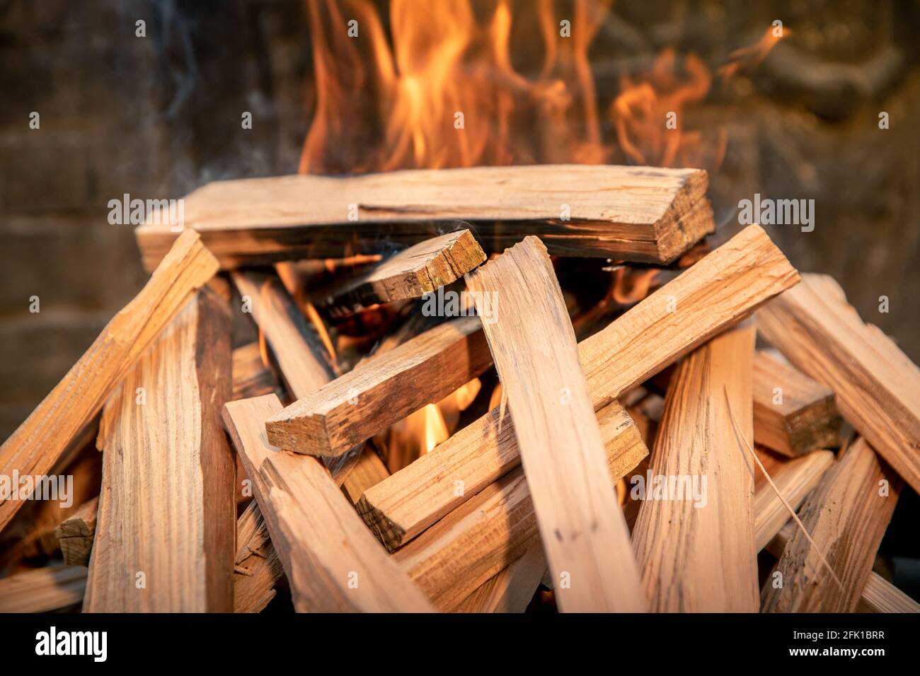 Closeup of pyre of burning wood with flames. Production of charcoal for