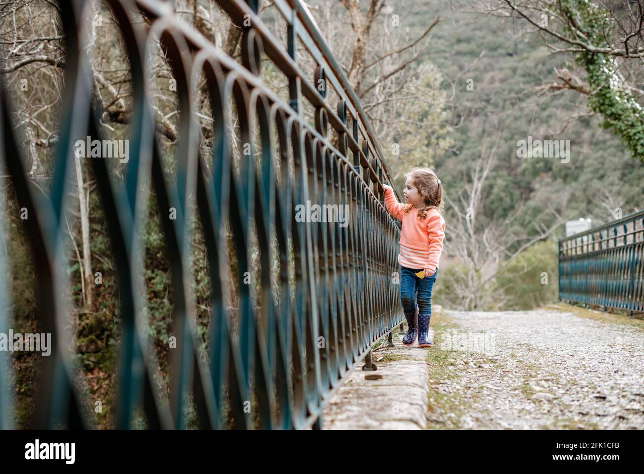 Small girl walks along old metal bridge in France Stock Photo