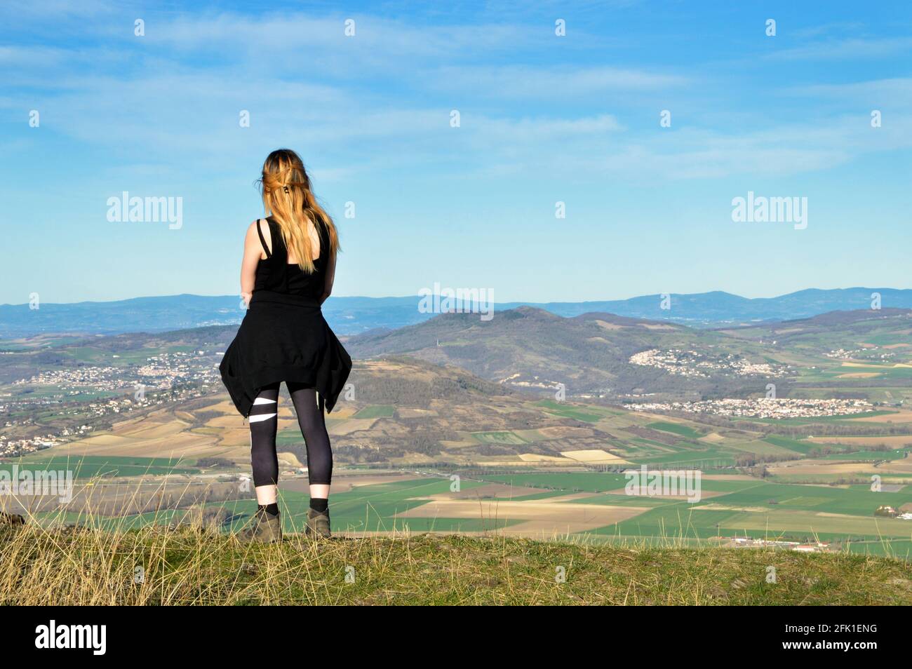A hiker on top of a mountain with a beautiful view of volcanic mountains Stock Photo