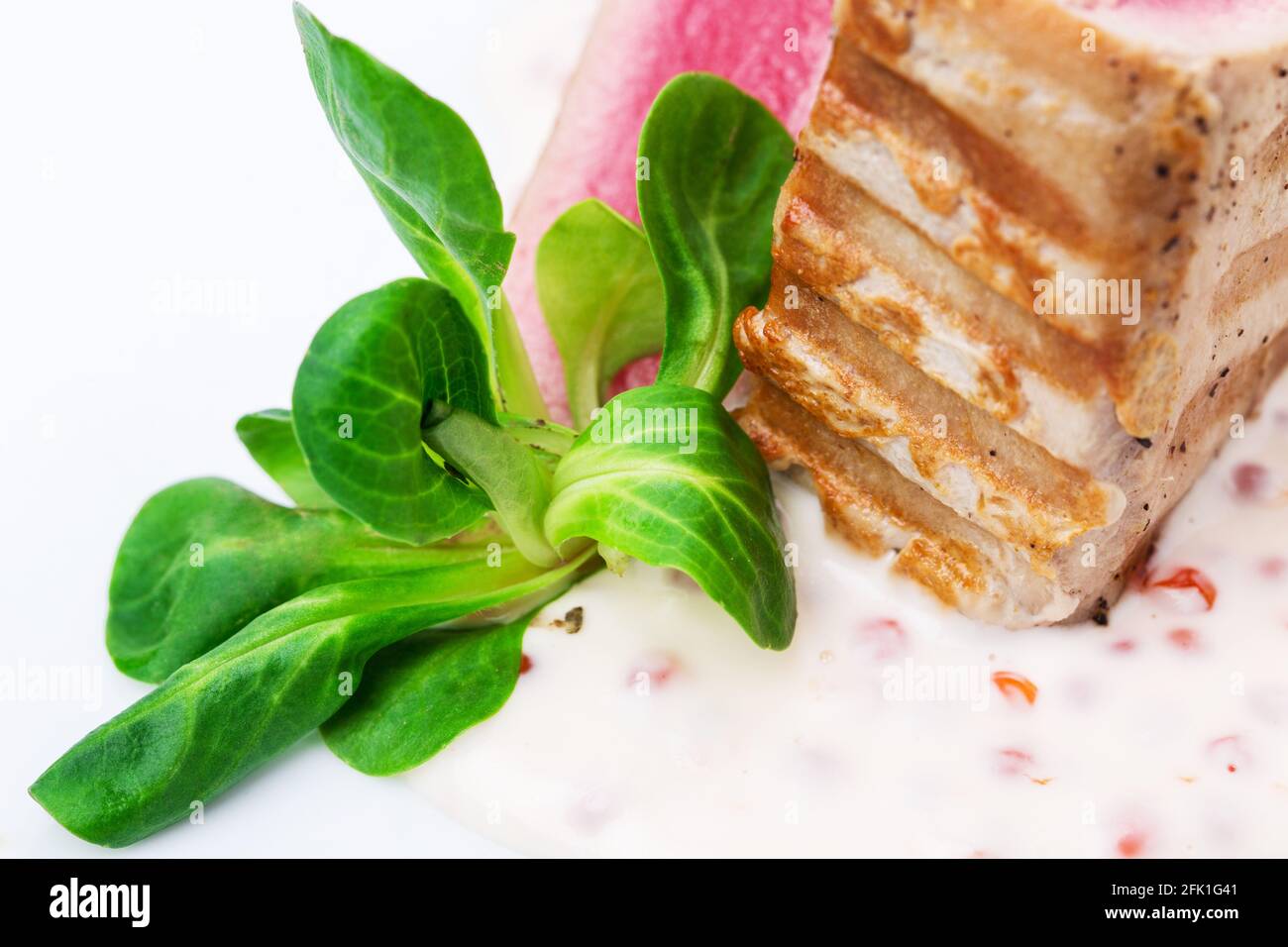 Grilled tuna fillet with corn salad and delicious sauce. Macro. Photo