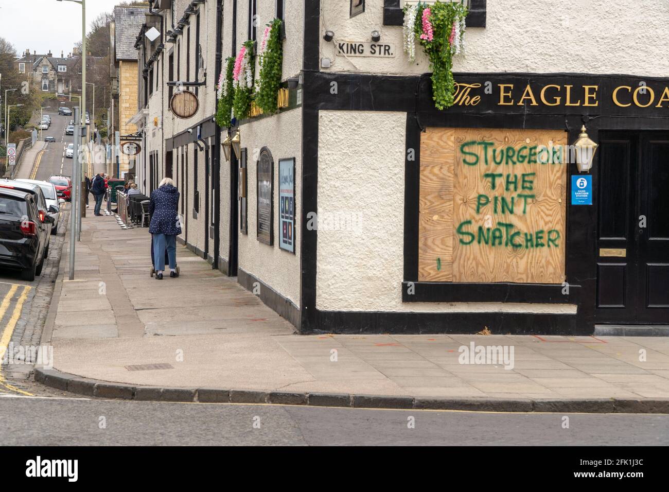 Broughty Ferry, Dundee, Tayside, Scotland, 26th of Apr 2021: Scottish government eased lockdown restrictions, allowing pubs to reopen in an outside environment, However some pubs don't have this facility available to them, and remain closed. Leading to frustration, as seen here, at The Eagle Coaching Inn, situated in the heart of Broughty Ferry, graffiti is sprayed on a boarded up window, “sturgeon the pint snatcher” referring to the first minister decision to place restrictions on how pubs must operate in an outdoor environment, as Scotland moves from a full lockdown, into a level 3 lockdown. Stock Photo
