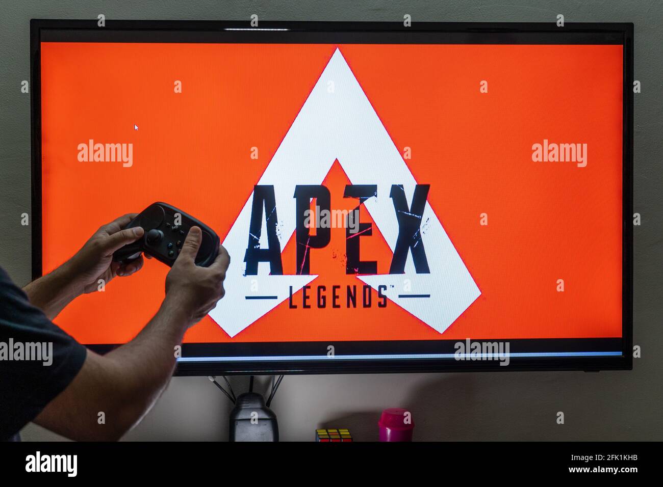 man with a controller standing in front of a PC console TV screen with a  steam controller playing popular free to play game Roblox Stock Photo -  Alamy