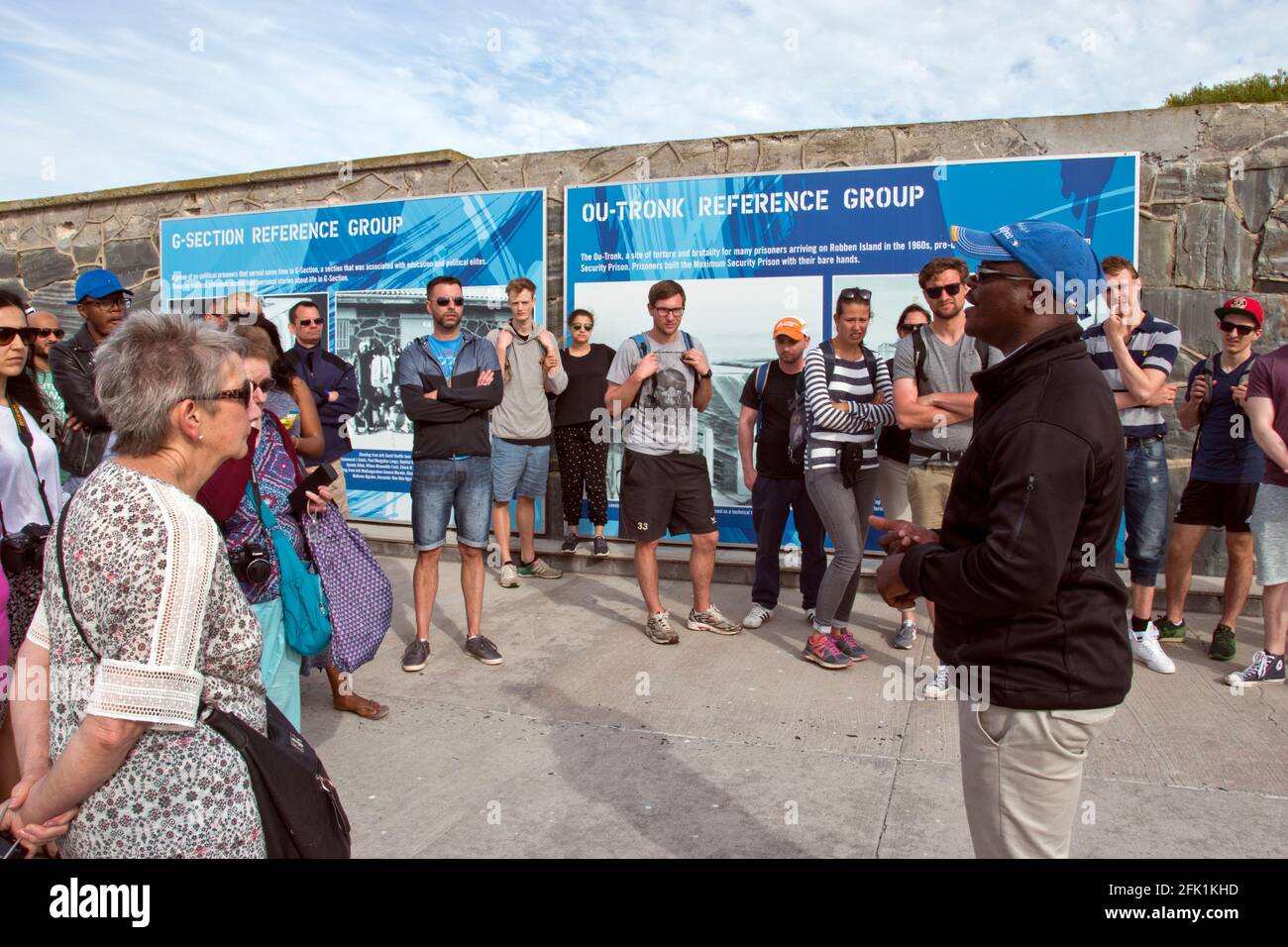 A tour guide speaks to tourists at Robben Island, where Nelson Mandela was imprisoned during apartheid, in Table Bay, Cape Town, South Africa. Stock Photo