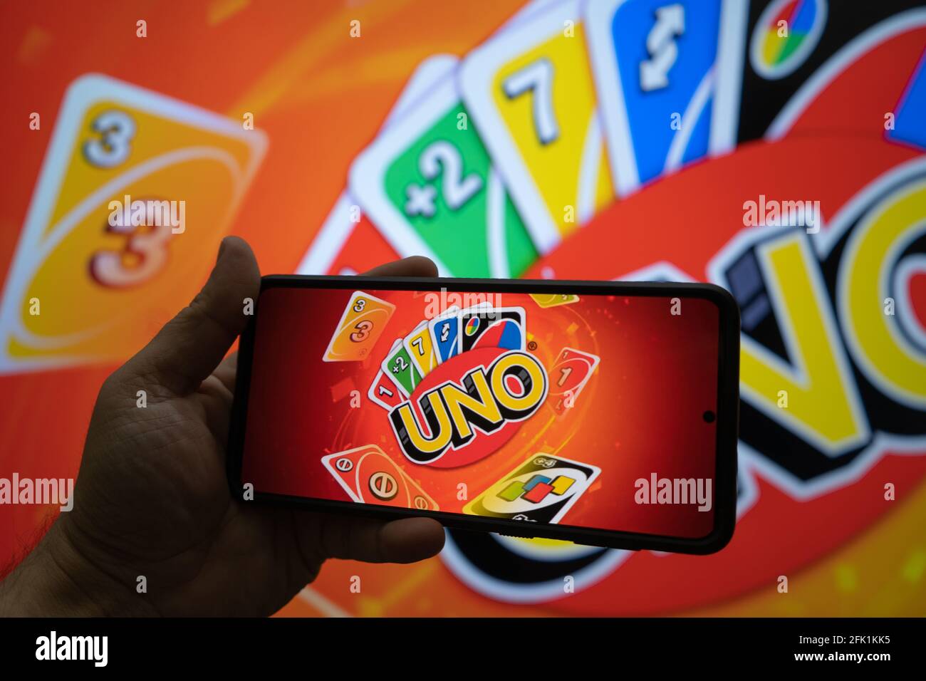 Man holding a mobile phone with an application allowing them to play the  popular card game Uno during travel online with players worldwide Stock  Photo - Alamy