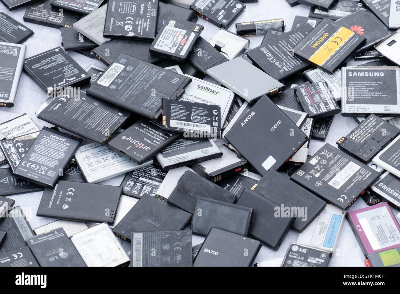Prague, CZ 25 April 2021: Used cell mobile phone different brands batteries in the market.  lot of Lithium rechargable  Recycling lithium.  EDITORIAL Stock Photo