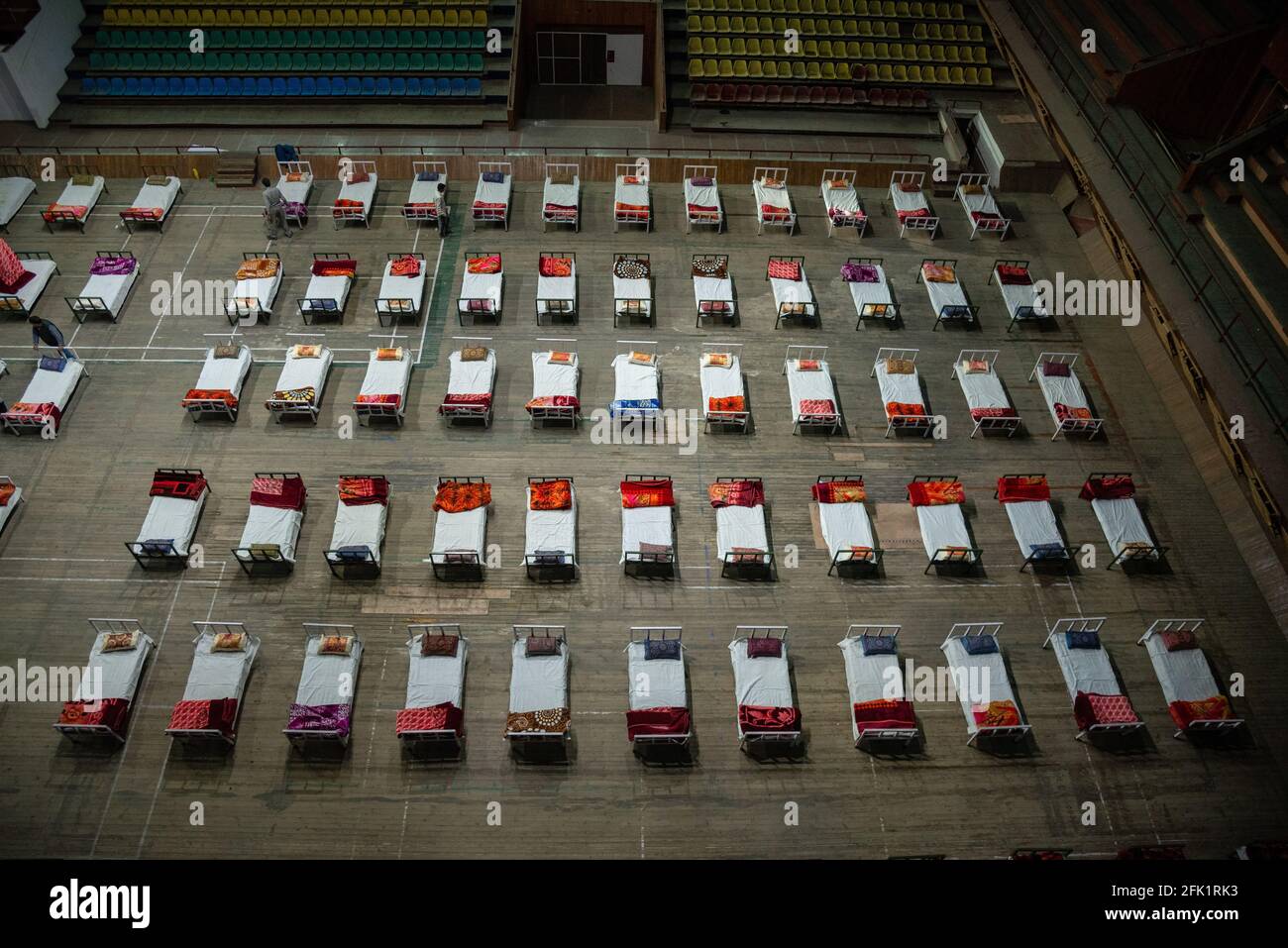 Srinagar, India. 27th Apr, 2021. Rows of beds are placed inside an indoor sports stadium turned COVID-19 isolation center in Srinagar. The Jammu and Kashmir reported 3,164 positive cases, highest ever since the outbreak of Covid-19 pandemic last year, pushing the number of active cases to 22,283 which otherwise were less than 600 around a month before. A 20 year old woman was reported among the Twenty five deaths in J&K in the last 24 hours taking the death toll to 2,197. (Photo by Idrees Abbas/SOPA Images/Sipa USA) Credit: Sipa USA/Alamy Live News Stock Photo