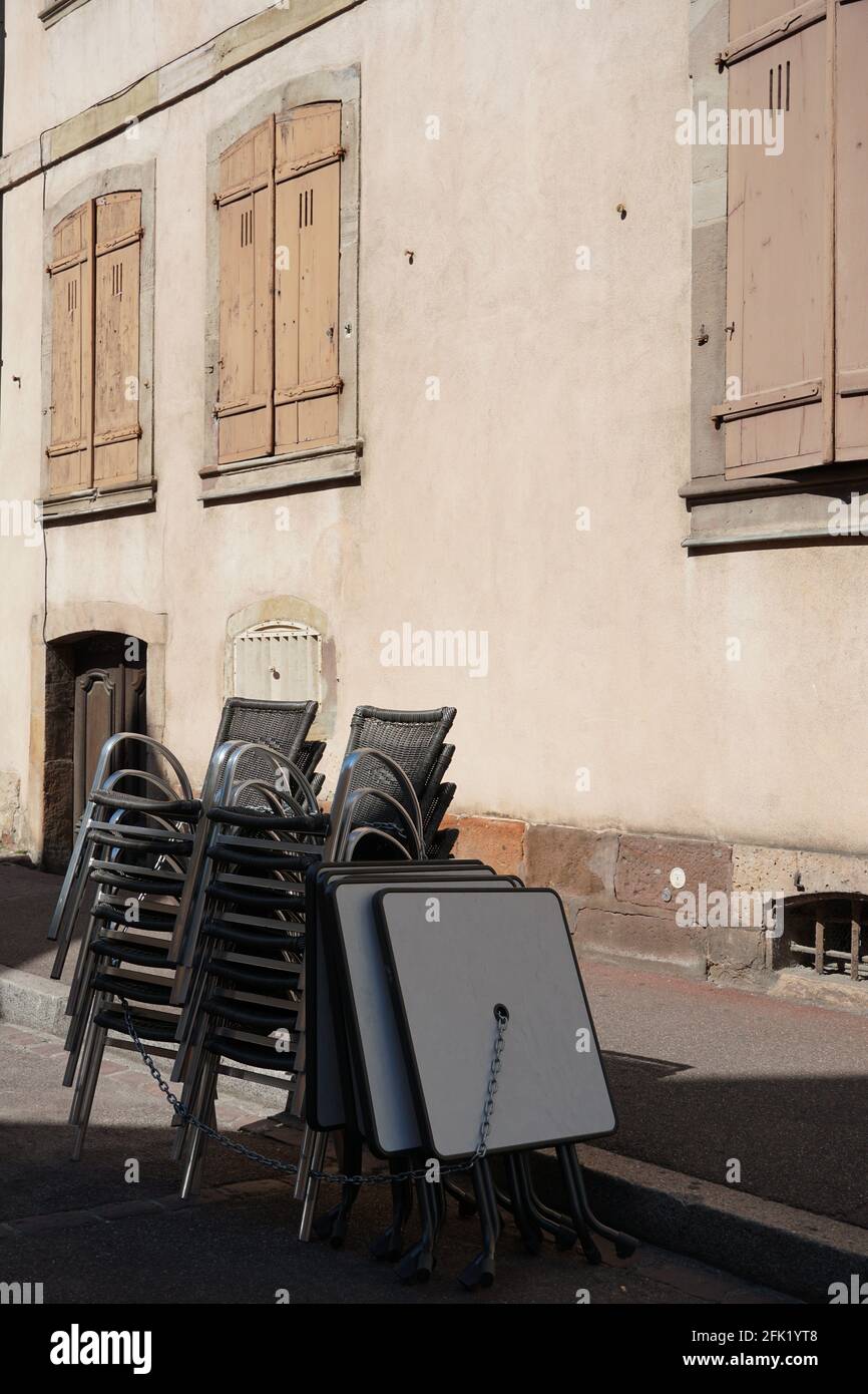 Stapled chairs and tables of a  closed terrace restaurant with copy space in Colmar, France. Gastronomy establishments are under lockdown. Stock Photo