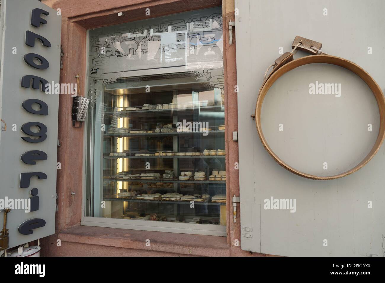 Cheese shop written in French on the facade of the building with shop window with display of different sorts of cheese. Stock Photo