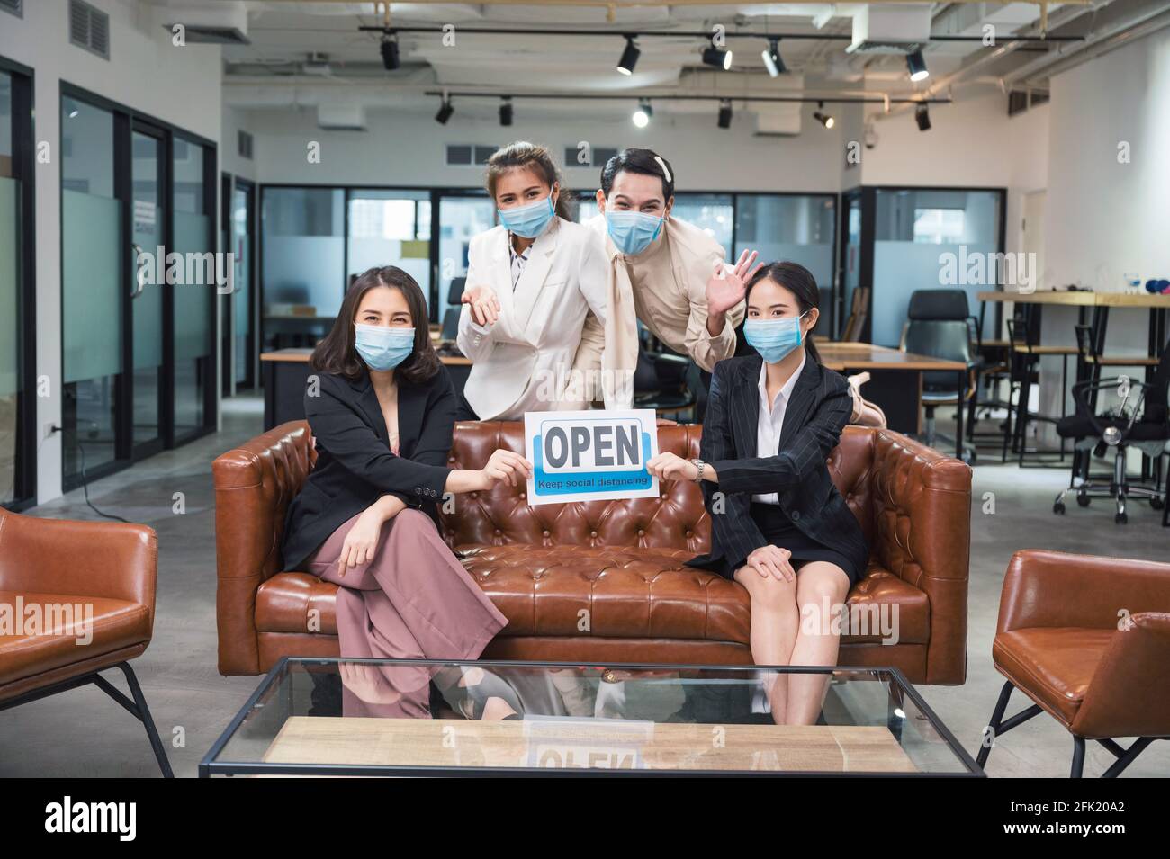 Group of asian business people wearing face mask sitting and holding ...