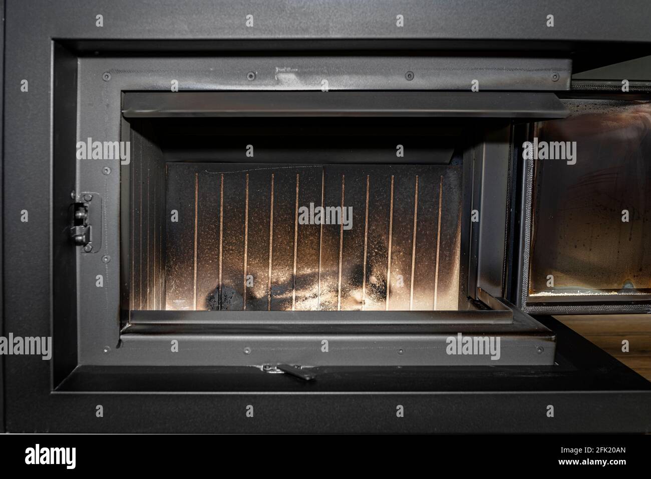Ceramic chamber in a modern fireplace with a closed combustion chamber standing in the living room, fireplace interior. Stock Photo