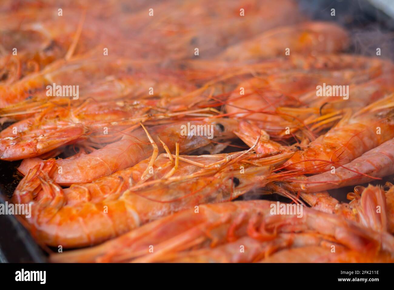 Process of cooking fresh red langoustine shrimps, prawns on grill