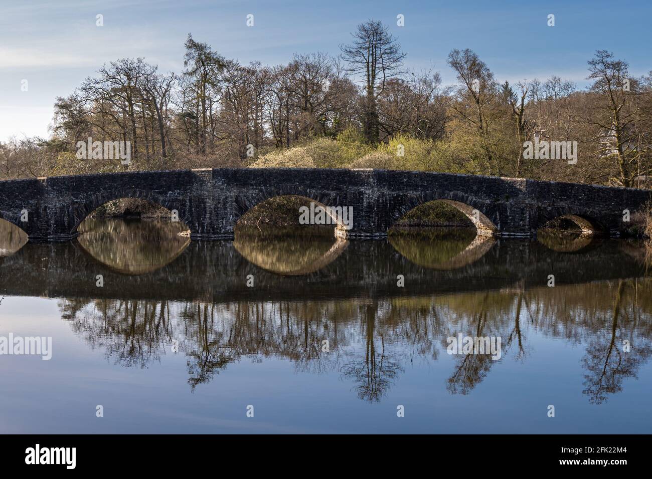 Early morning mirror-like reflection of the bridge over the River Leven at Newby Bridge Stock Photo