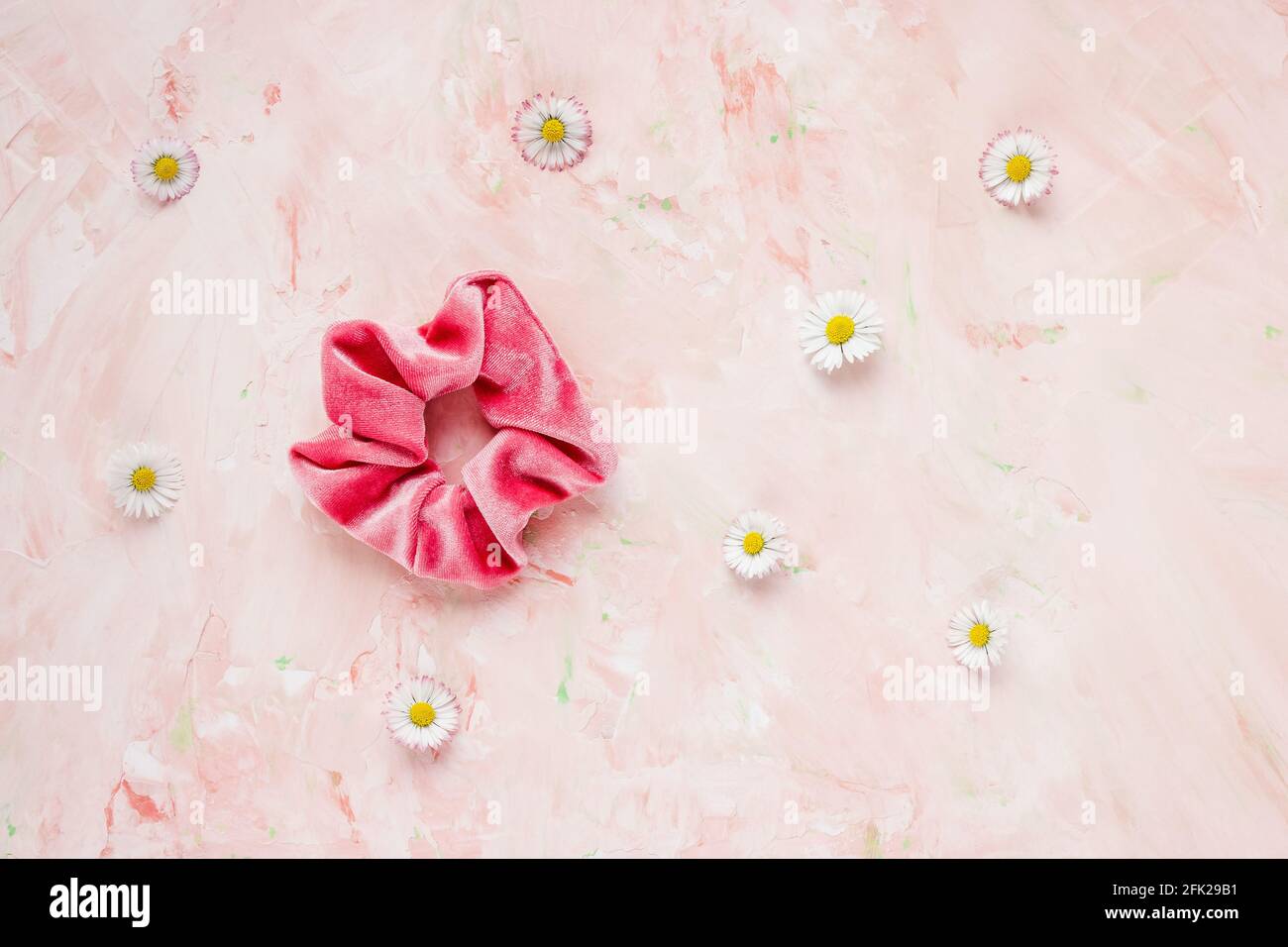Pink velvet scrunchie and fresh spring flowers Stock Photo