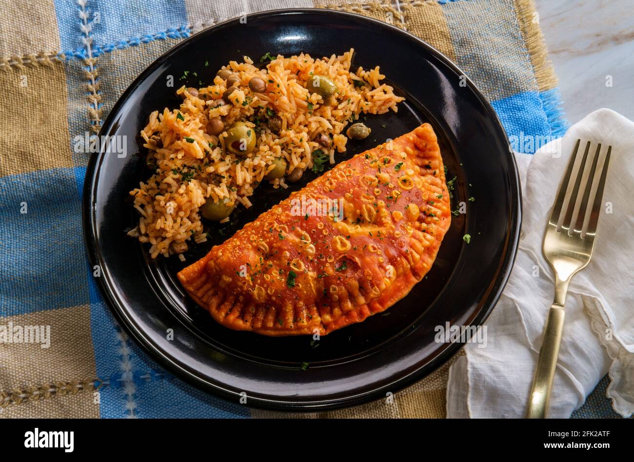 Mexican fried empanada meat pies with olive caper rice Stock Photo - Alamy