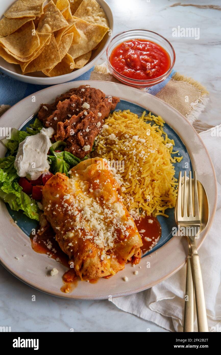 Traditional Mexican enchiladas dinner served with rice and refried ...