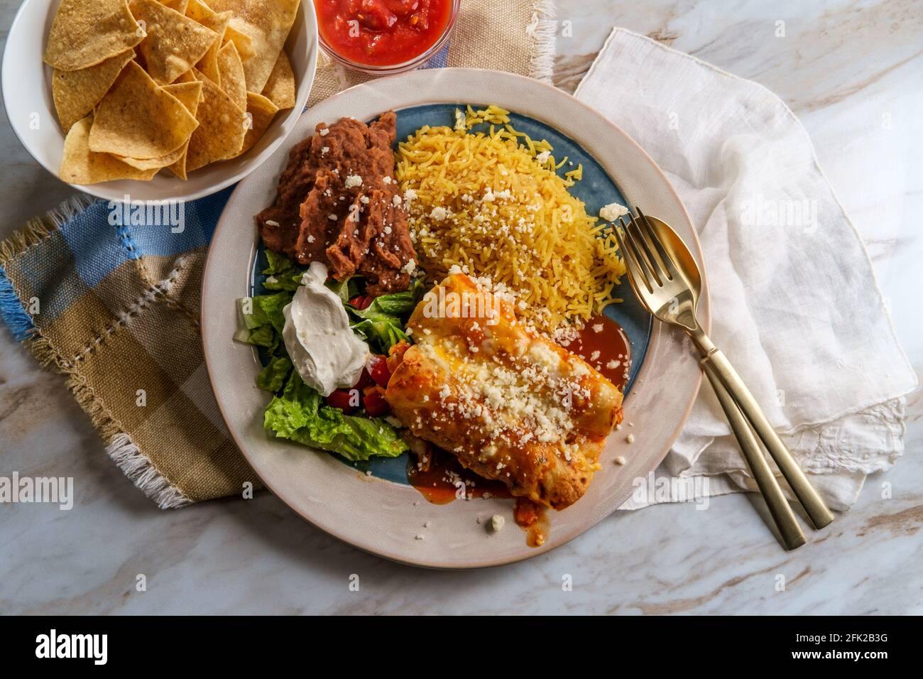 Traditional Mexican enchiladas dinner served with rice and refried ...