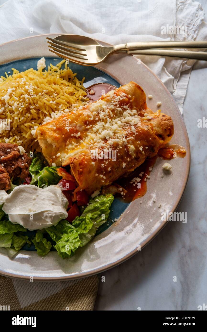 Traditional Mexican enchiladas dinner served with rice and refried ...