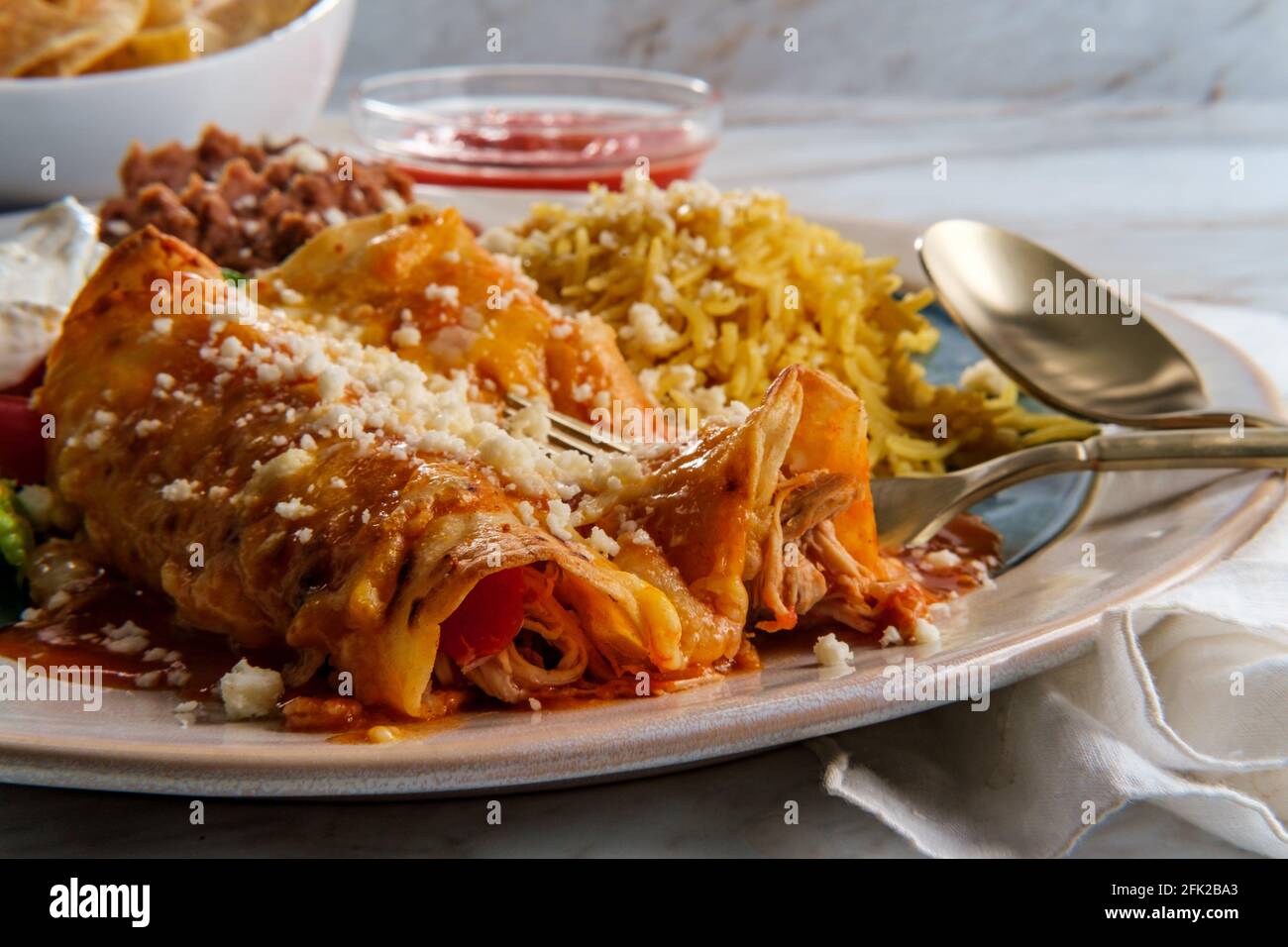 Traditional Mexican enchiladas dinner served with rice and refried ...