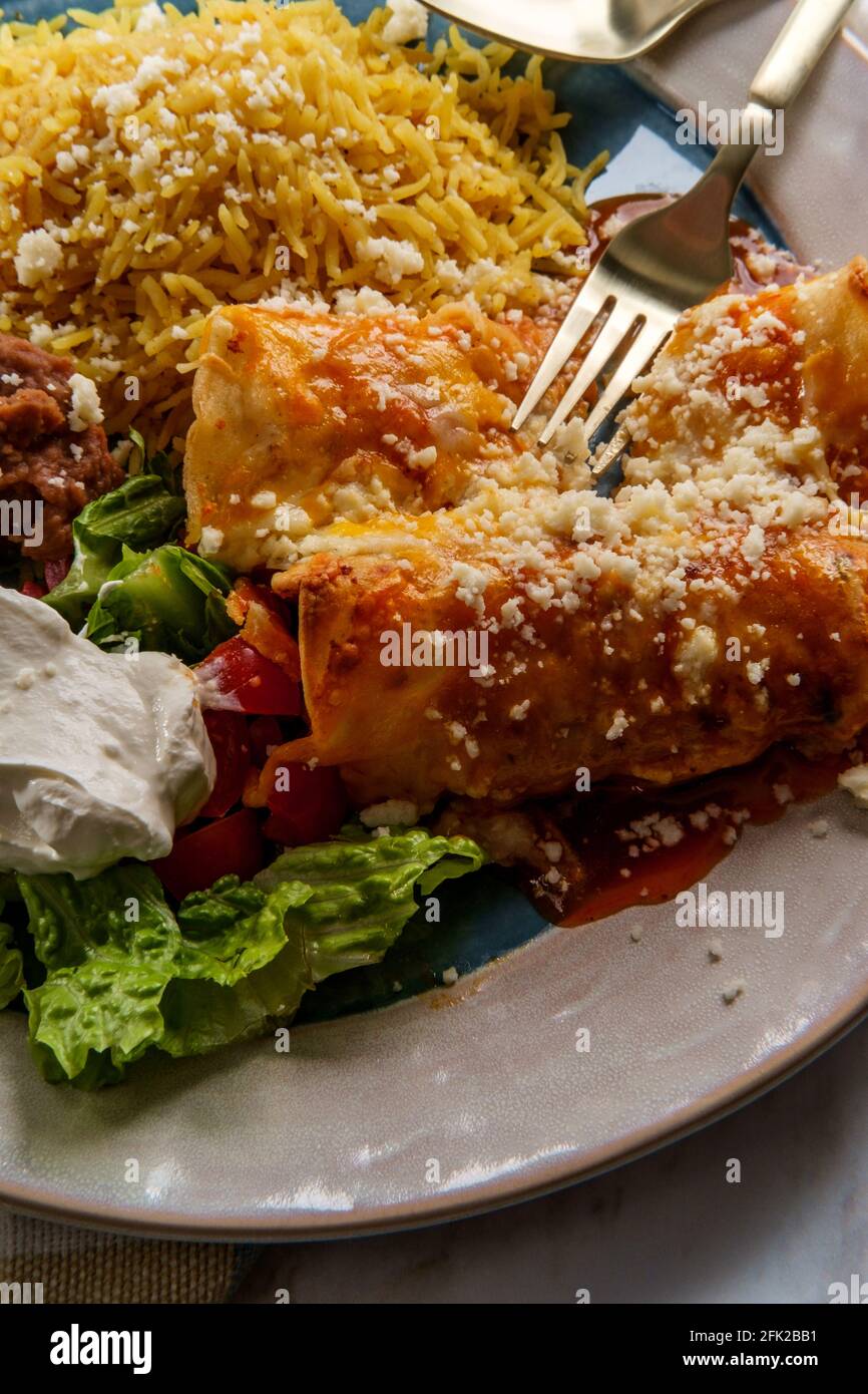 Traditional Mexican enchiladas dinner served with rice and refried ...
