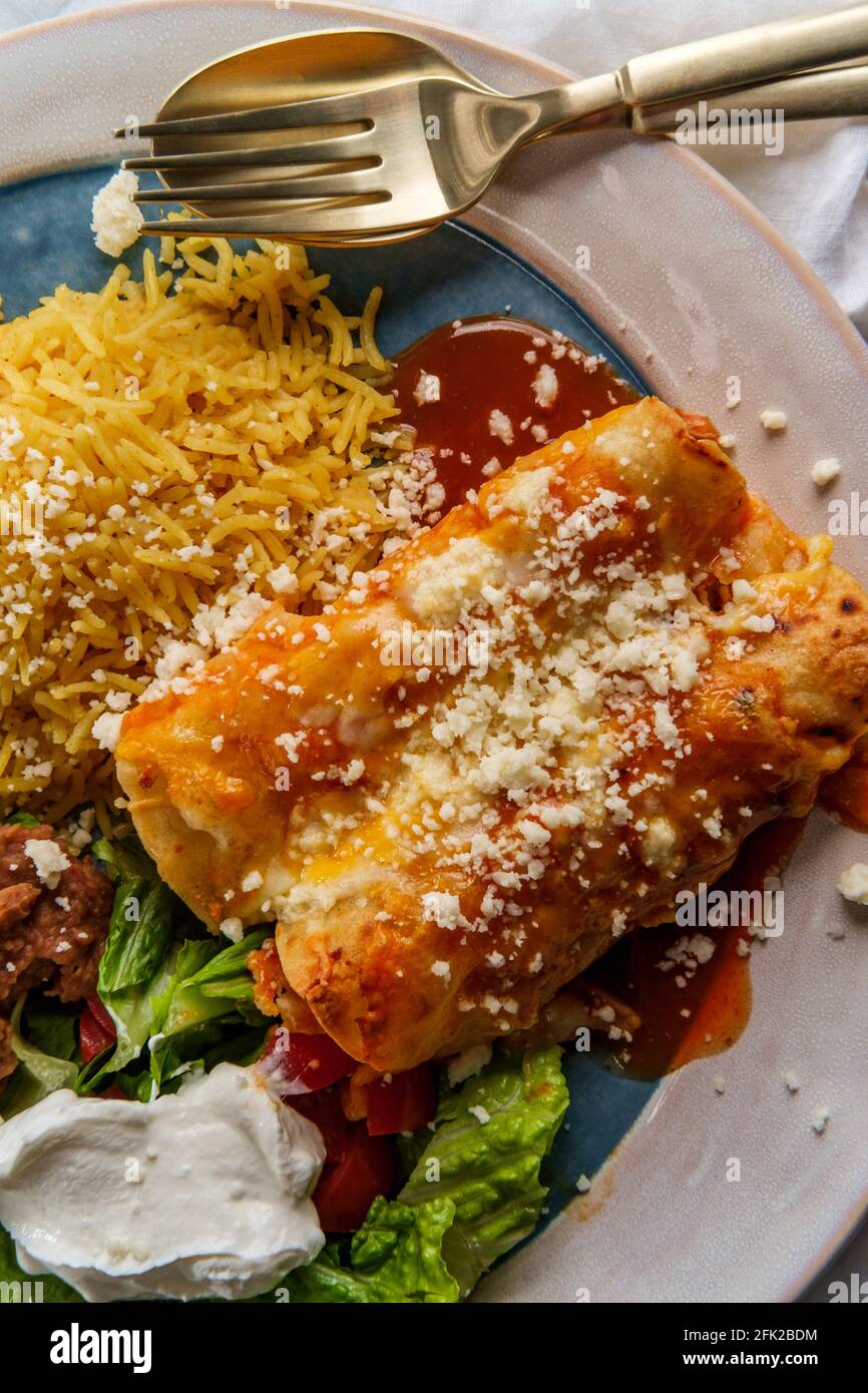 Traditional Mexican enchiladas dinner served with rice and refried ...