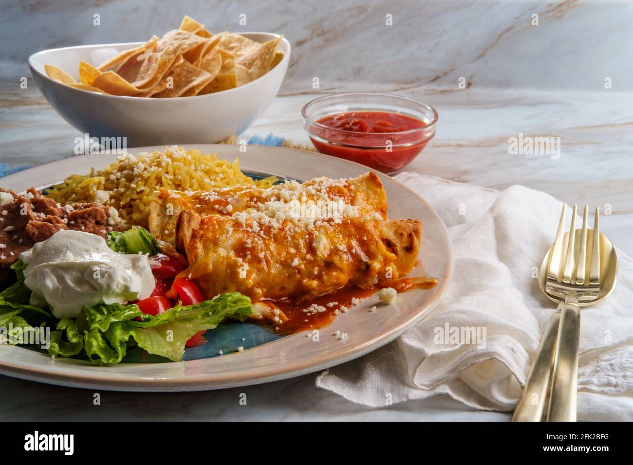 Traditional Mexican enchiladas dinner served with rice and refried ...