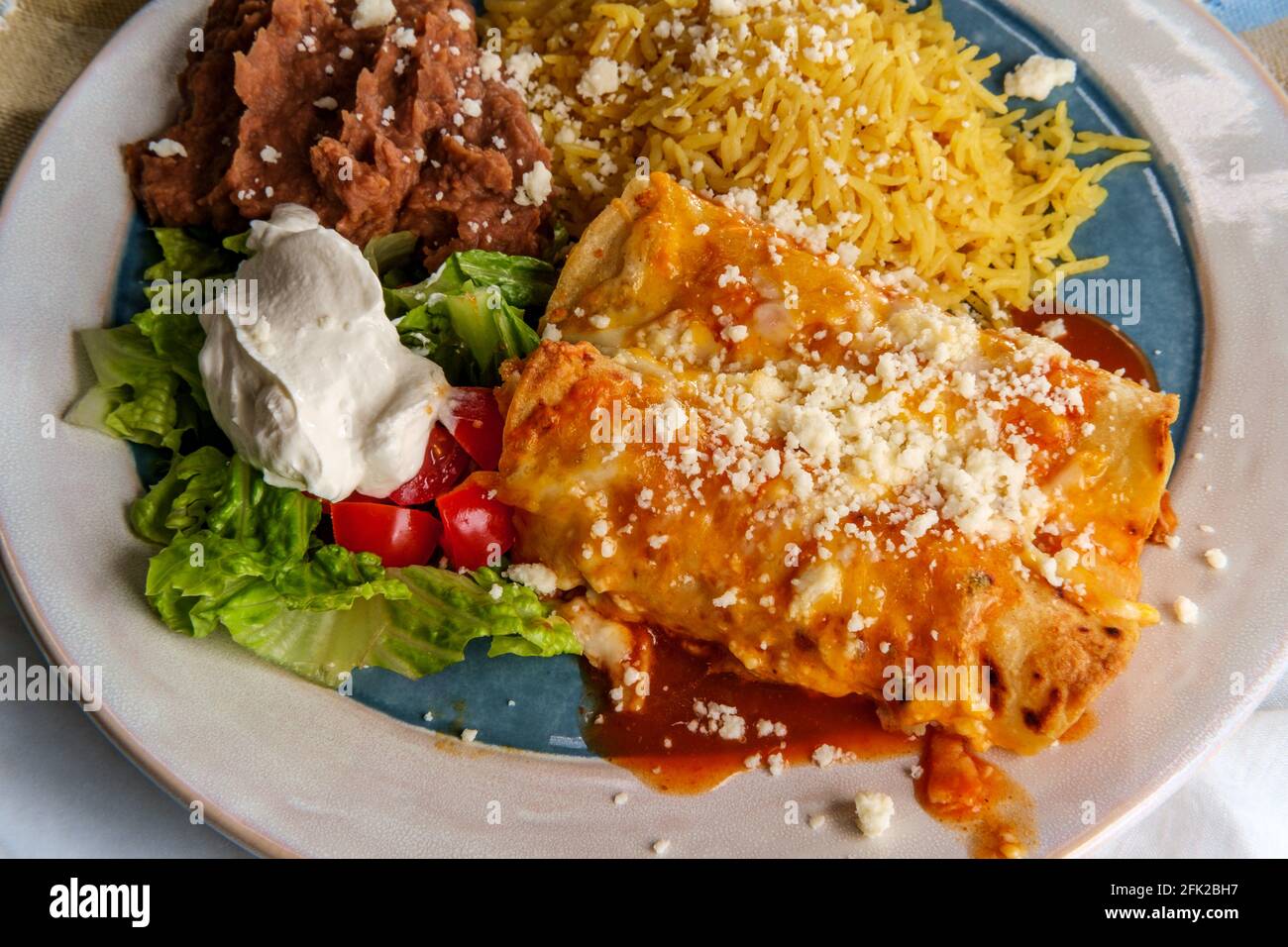Traditional Mexican enchiladas dinner served with rice and refried ...