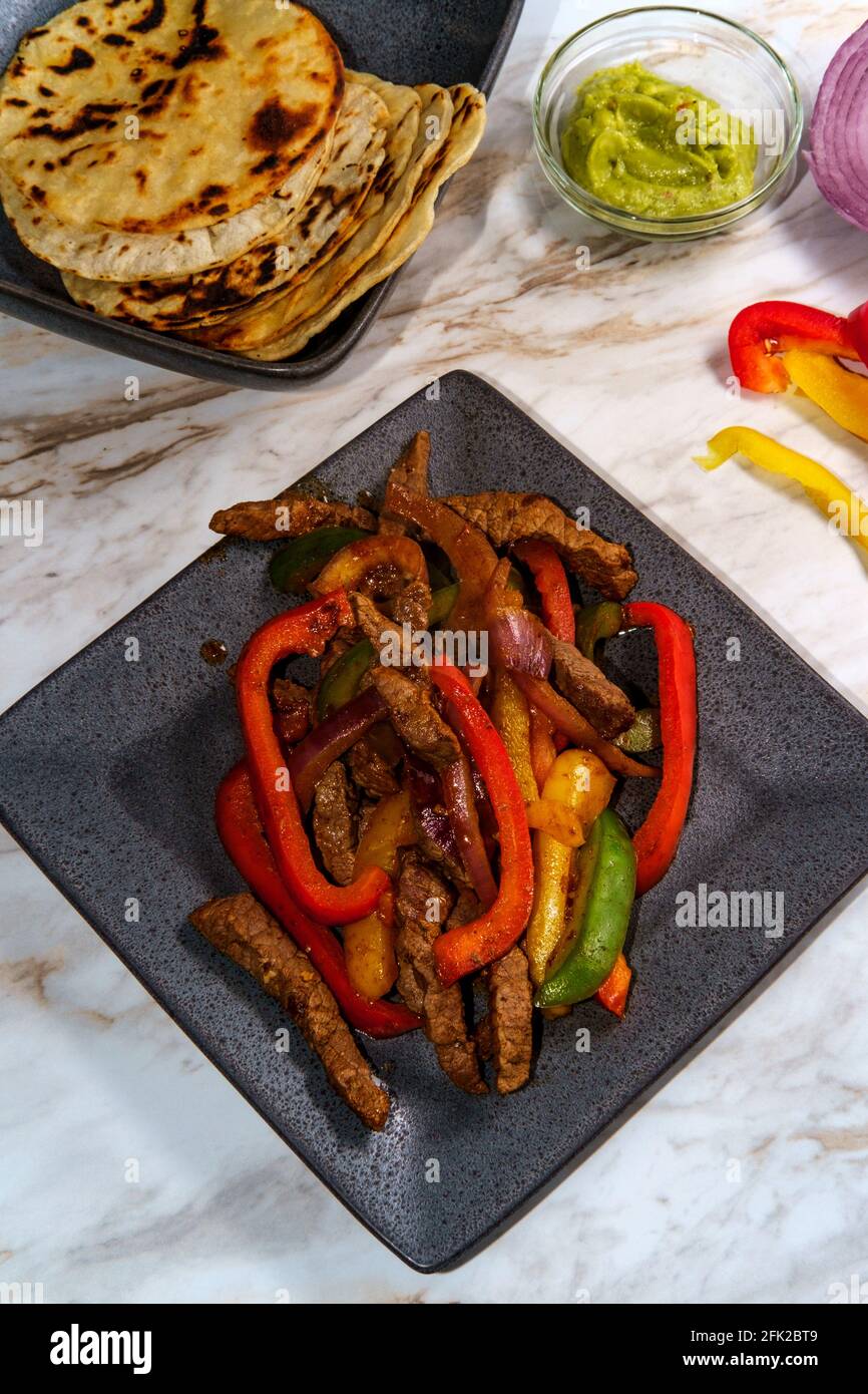 Mexican steak fajitas with fried corn tortillas and guacamole Stock