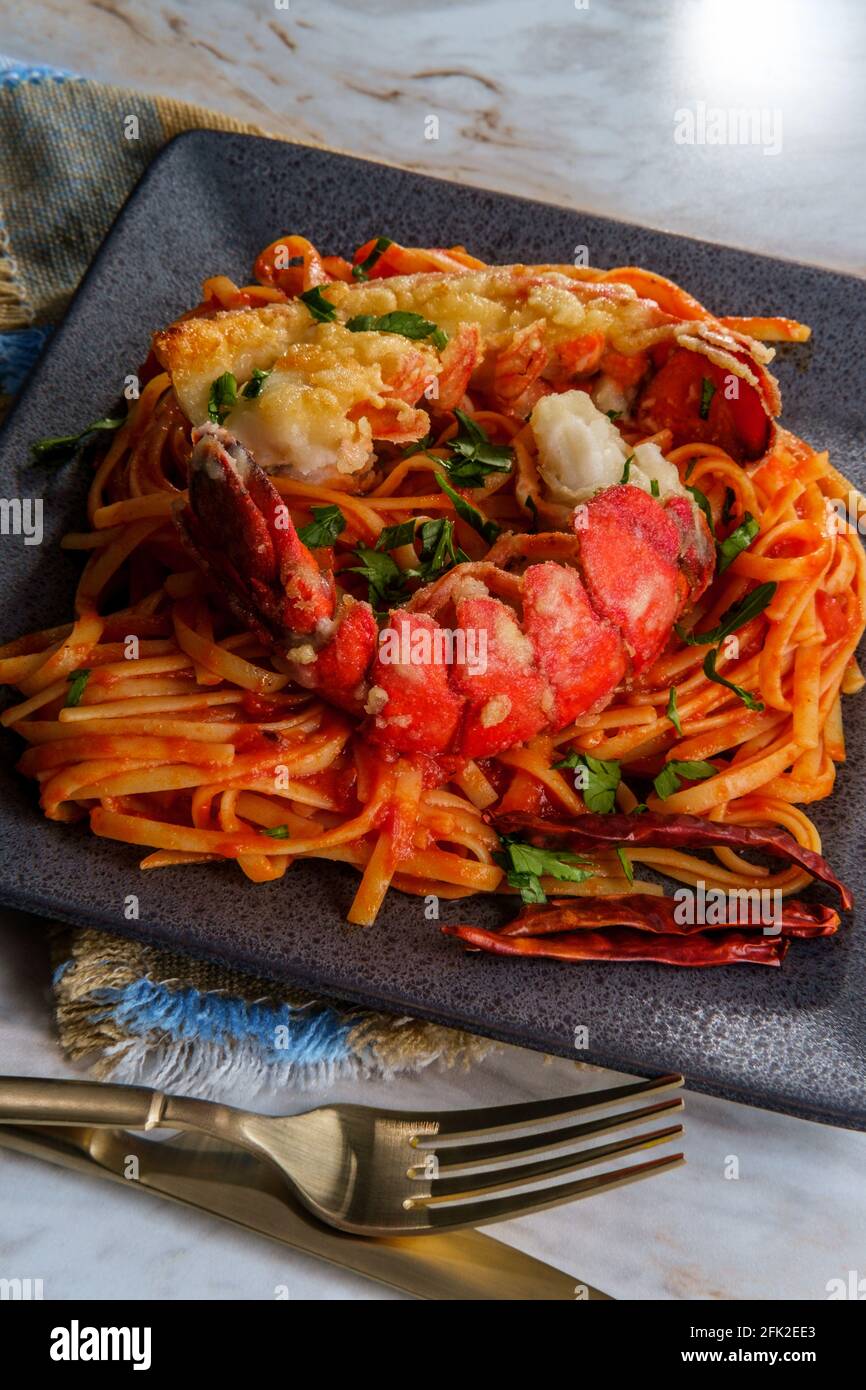 Pan fried sliced Italian lobster tail fra diavolo linguine Stock Photo
