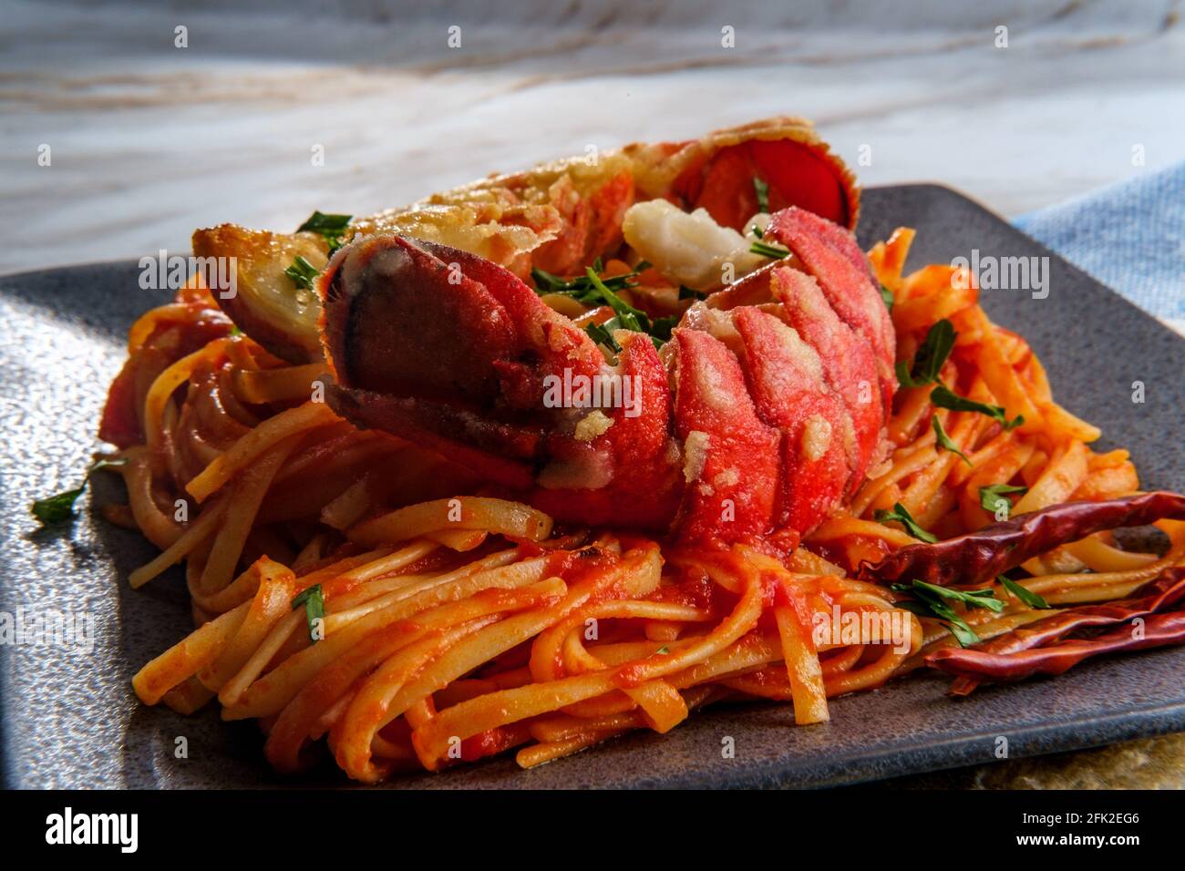 Pan fried sliced Italian lobster tail fra diavolo linguine Stock Photo