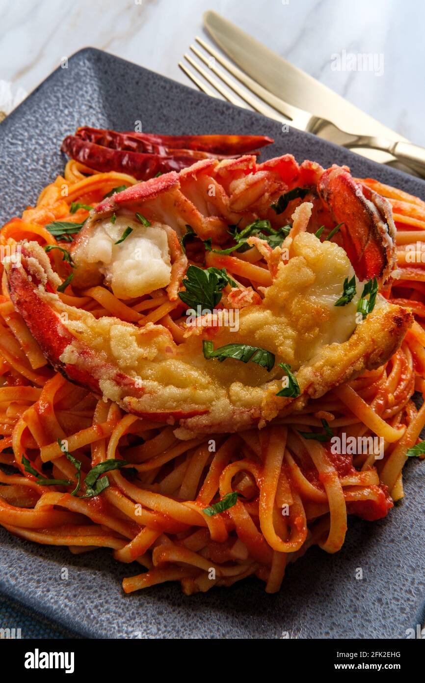 Pan fried sliced Italian lobster tail fra diavolo linguine Stock Photo