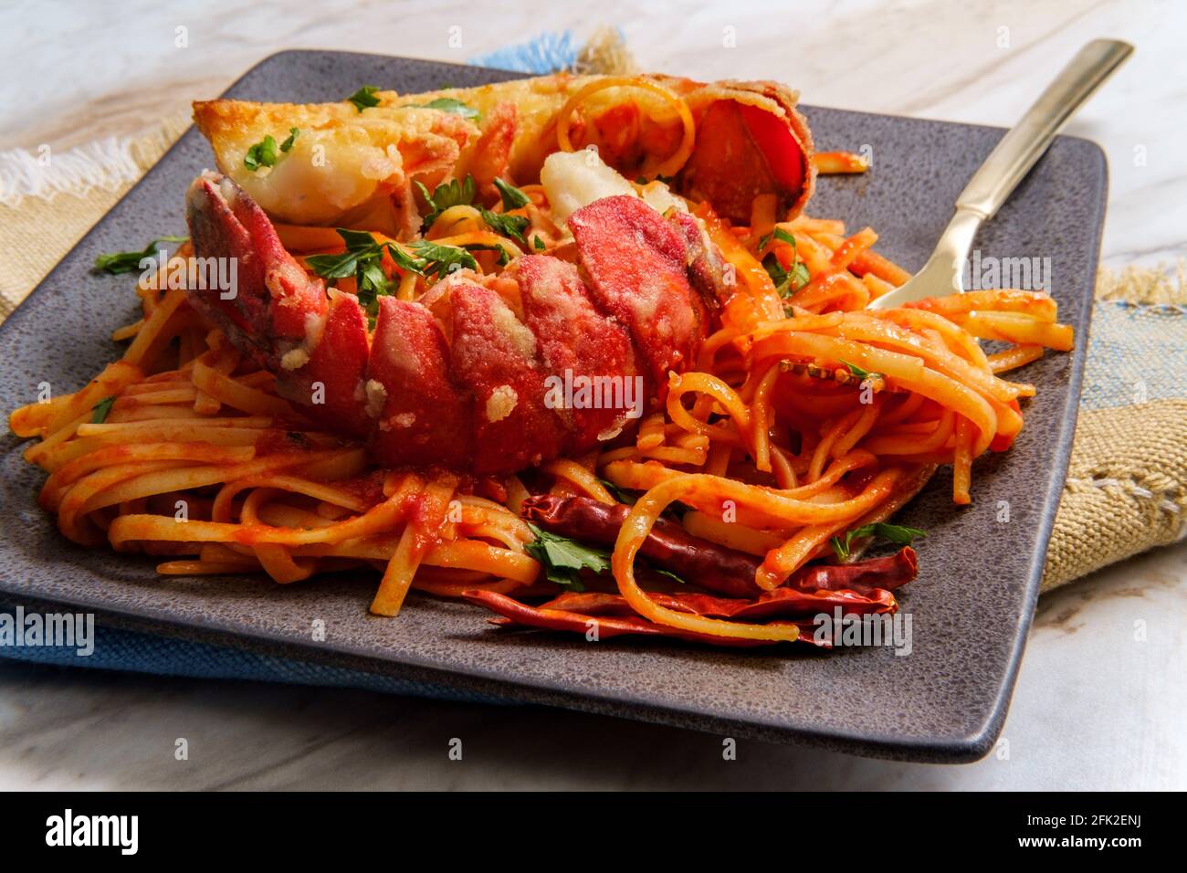 Pan fried sliced Italian lobster tail fra diavolo linguine Stock Photo