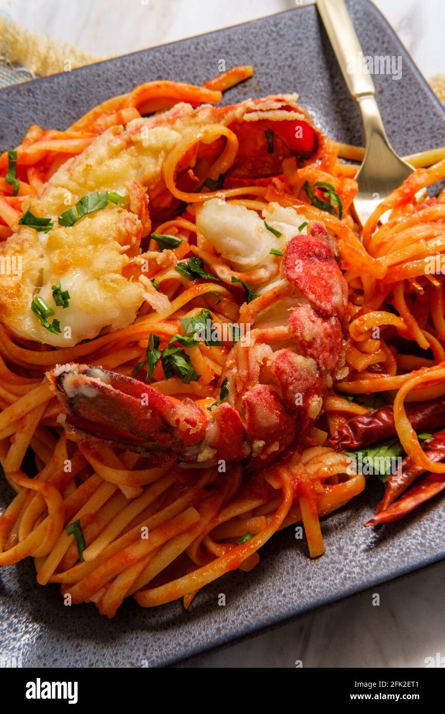 Pan fried sliced Italian lobster tail fra diavolo linguine Stock Photo