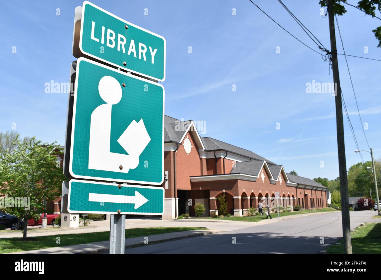 Library sign pointing at a library Stock Photo