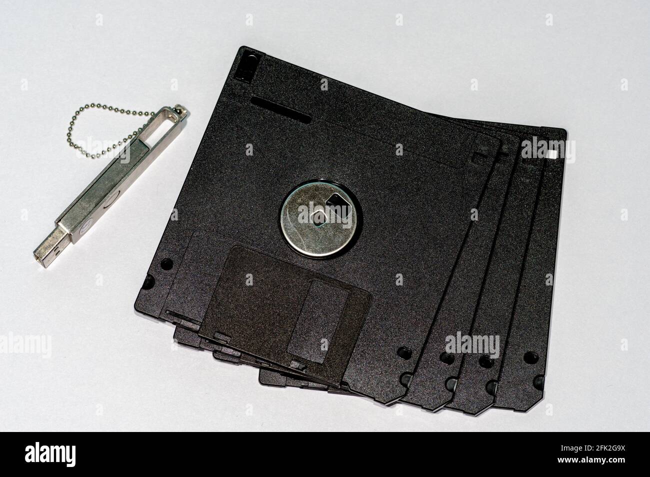 Top view of floppy disks and a flash drive on a clear surface Stock