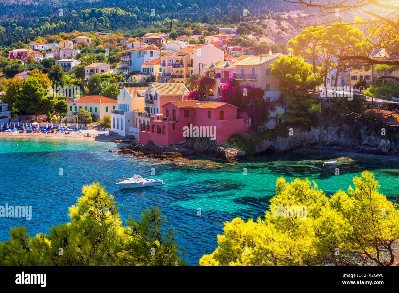 Turquoise colored bay in Mediterranean sea with beautiful colorful houses  in Assos village in Kefalonia, Greece. Town of Assos with colorful houses  on the mediterranean sea, Greece. Stock Photo