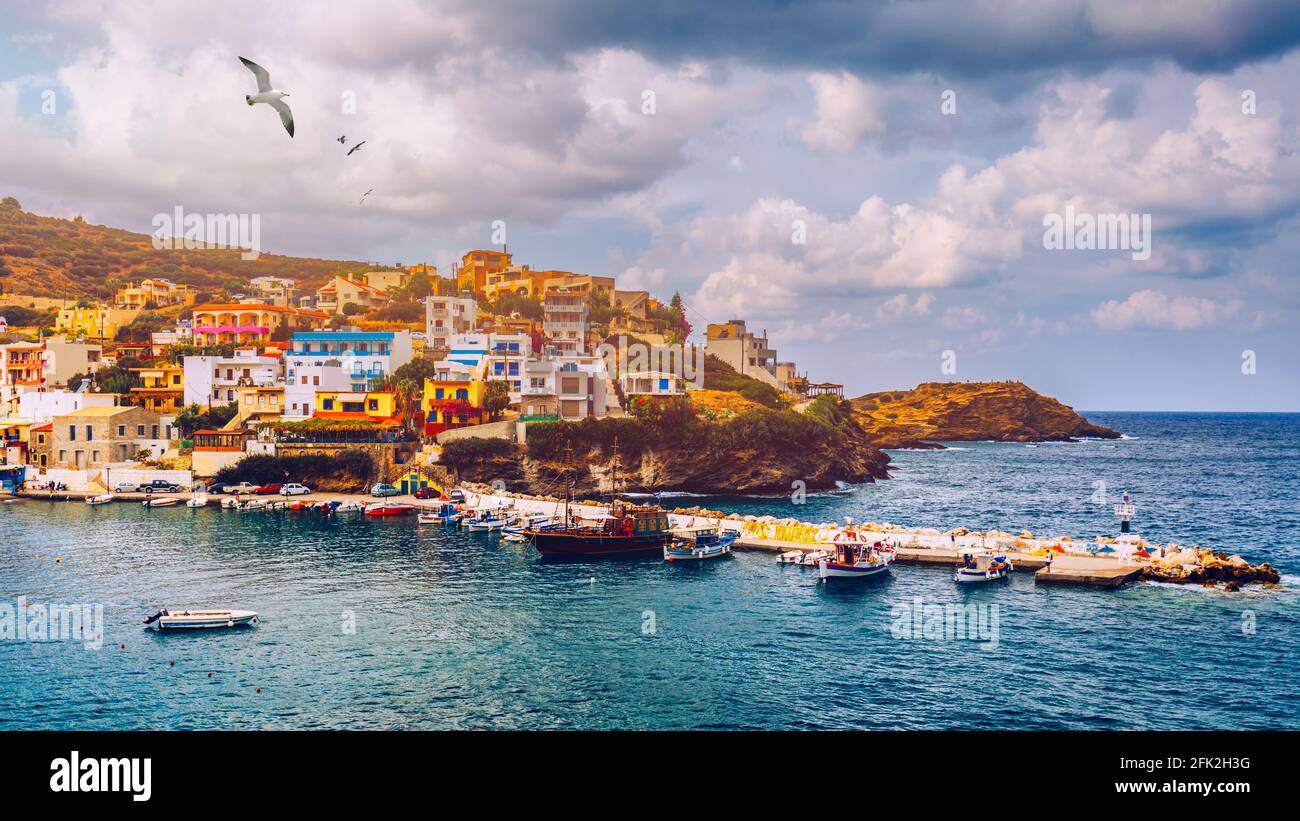 Panorama of Harbour with vessels, boats, beach and lighthouse in Bali at sunrise, Rethymno, Crete, Greece. Famous summer resort in Bali village, near Stock Photo