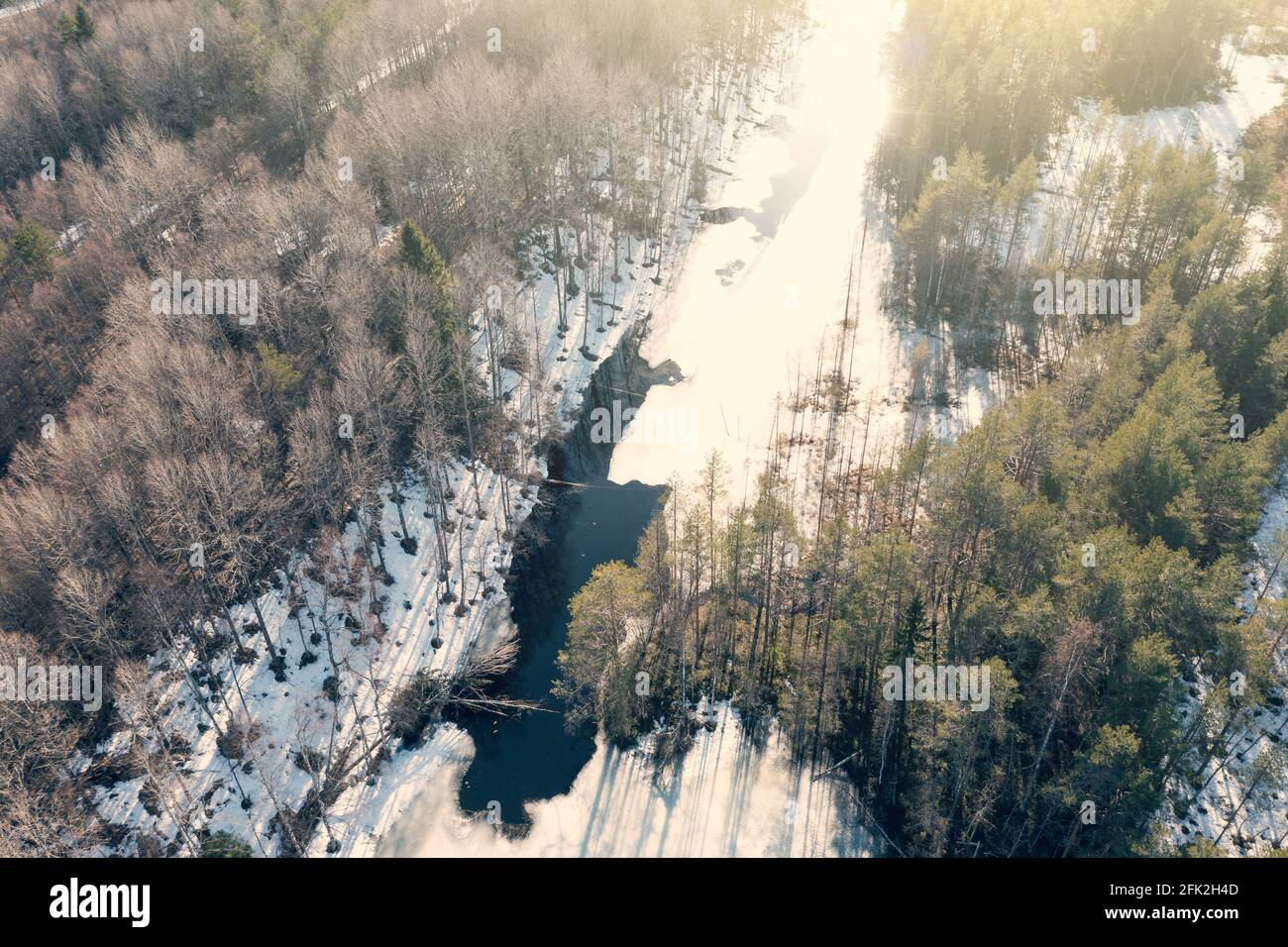 Frozen river in sunny spring day, aerial flight on drone above Karelian nature landscape. Stock Photo