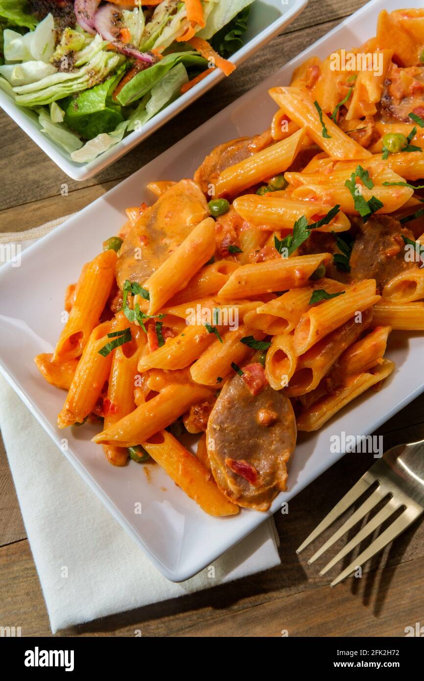 Italian penne alla vodka pink cream sauce with sliced spicy sausage and