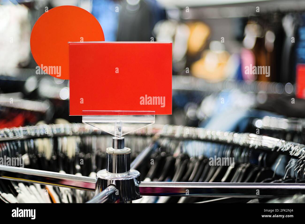 Blank shopmark price tag on retailer display stand rack in fashion textiles shop store retail retailing Stock Photo