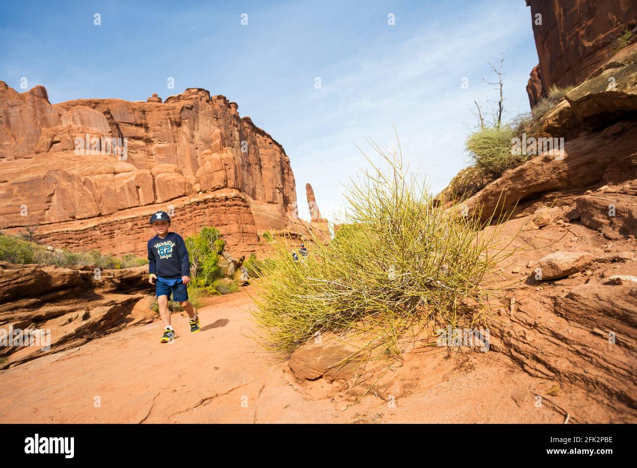 Young boy hiking on the Park Avenue trail in Arches  National Park, Utah, USA. Stock Photo