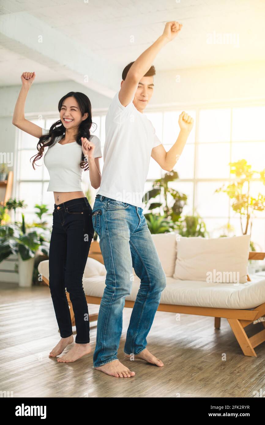 Happy young couple  dancing in living room at home Stock Photo