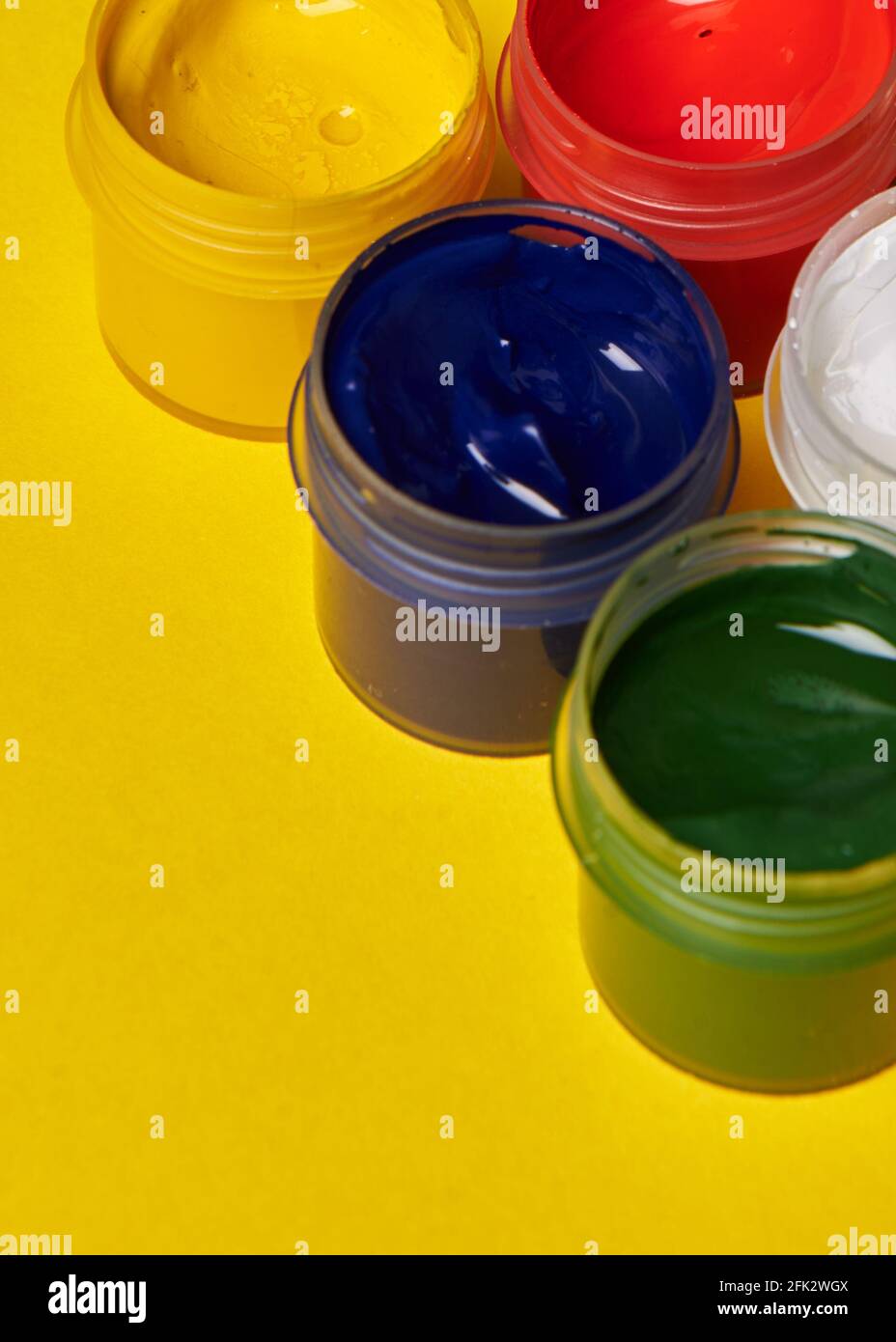 multicolored cans of paint on a yellow background Stock Photo